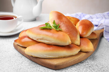 Tasty baked patties on grey textured table, closeup