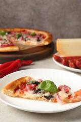 Slice of tasty pizza with thin smoked sausages served on light table, closeup