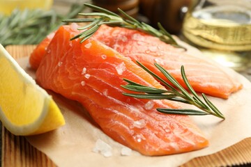 Seafood. Pieces of salmon fillet, spices, oil and lemon wedge on table, closeup