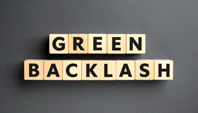 Text GREEN BACKLASH on wooden cubes on dark background. Anti-environmental movement. Flat lay.
