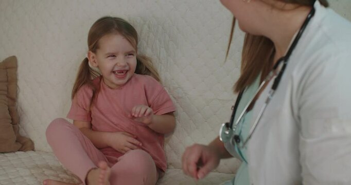A pediatrician provides a gentle health checkup for a little girl in the comfort of her own home, providing personalized pediatric care with a compassionate approach. Home visit by a pediatrician.