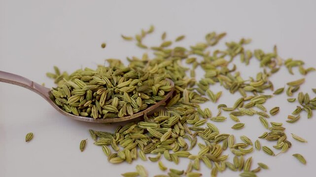 flat lay overhead dry fennel seed sounf isolated on white background. pile of dry fennel seeds sounf isolated. heap of dry fennel seeds sounf isolated food closeup in spoon.