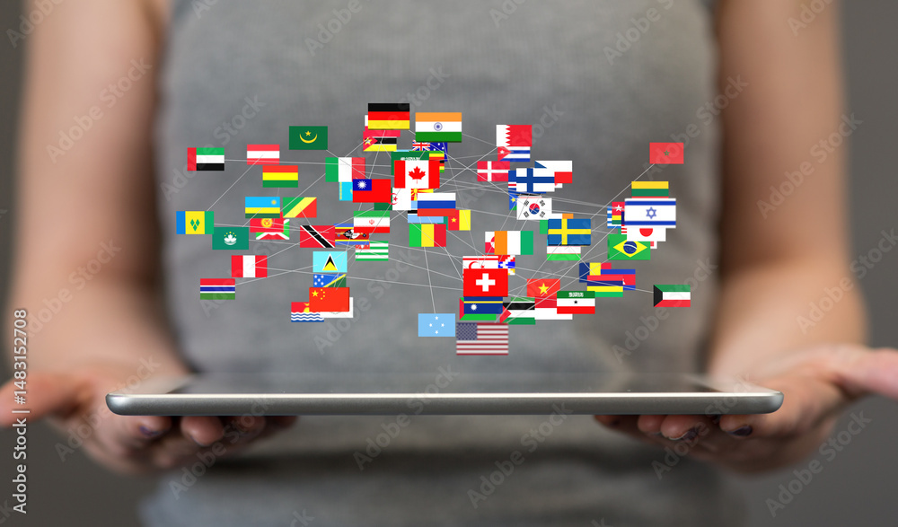 Poster image of many national flags interconnected, displayed on a tablet. represents global connectivity, 
