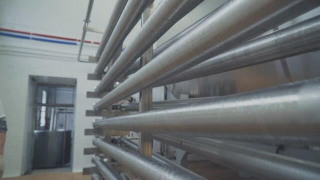 Close-up of heat exchanger stainless steel tubes at the dairy facility. Stainless steel tubes are used for milk pasteurization at the factory. Stainless steel tubes processing the dairy products. Milk