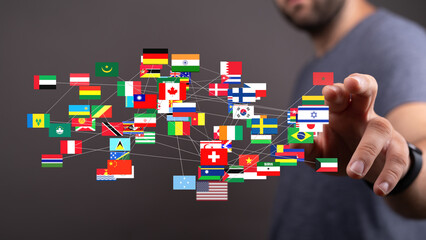 A man interacts with a digital display showing interconnected flags representing global networking...