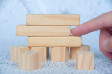 Hand pointing empty wooden blocks with customizable space for text.