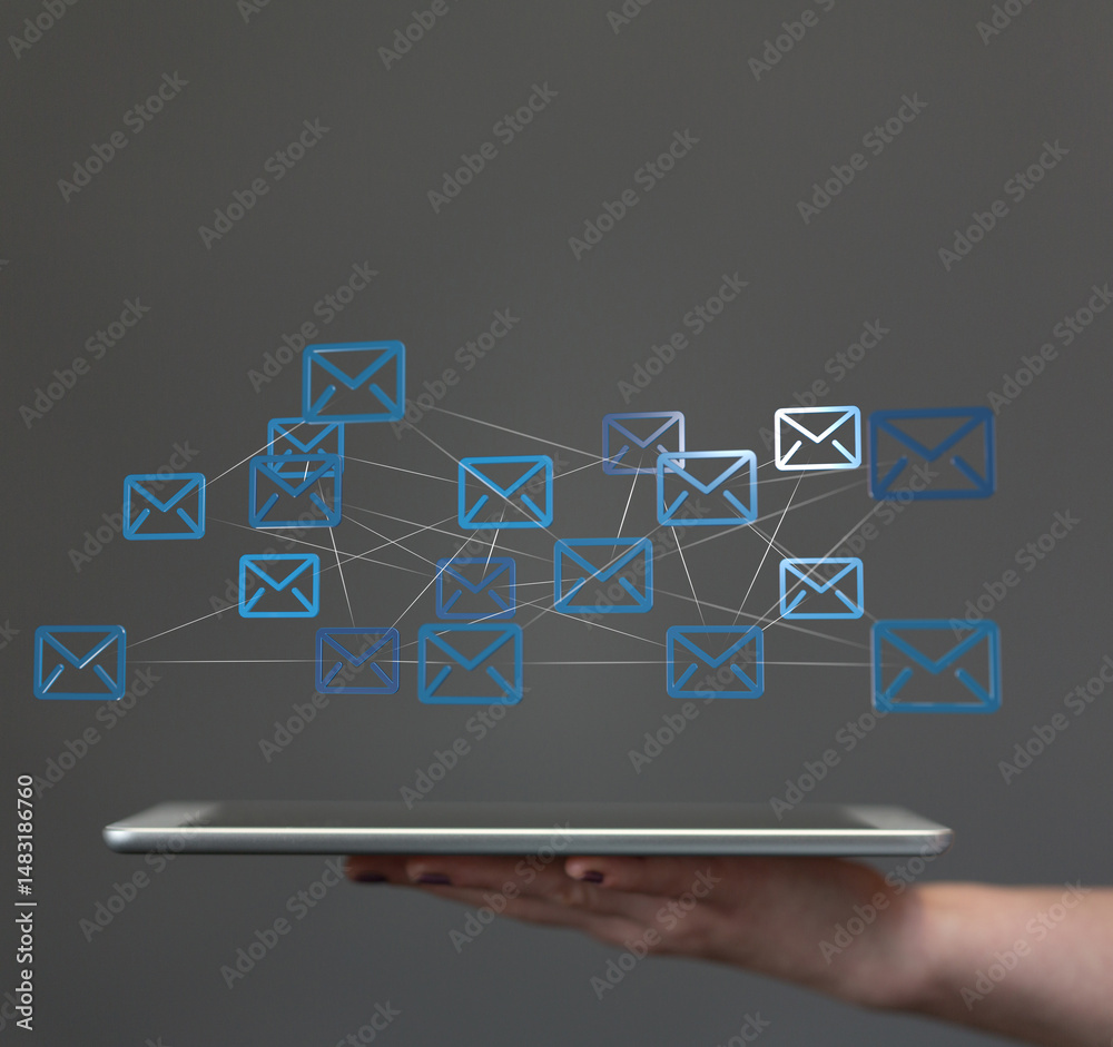 Aufkleber stock photo of a hand holding a tablet with a network of email icons. ideal for communication, techn