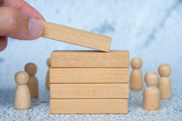 Hand placing wooden blocks with customizable space for text or ideas with wooden dolls background....