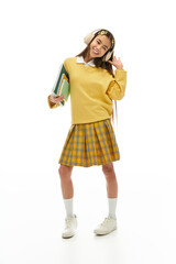 Stylish schoolgirl in trendy uniform poses confidently in a studio setting