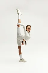 Gordijnen Stylish teenager strikes a dynamic pose in a bright studio setting © LIGHTFIELD STUDIOS