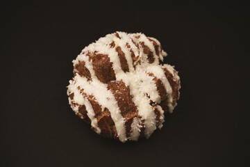 Profiteroles with coconut cream on a black background.