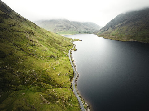 Atemberaubende Berglandschaft mit See und Stra&szlig;e in Irland