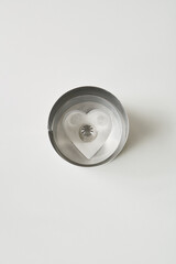 Metal heart-shaped cookie cutter resting on a white surface, ideal for baking and craft activities...