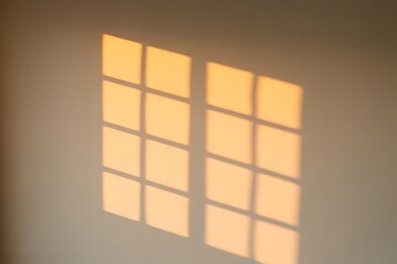 Warm Sunlight Casting a Window Shadow on a Beige Wall