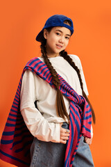 Stylish teenage girl showcasing a unique fashion sense in vibrant studio setting