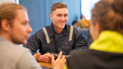 team of oil refinery engineers. wearing in safety wear, one man in casual wear, and another man in workwear . Business meeting, teamwork, and communication concept.