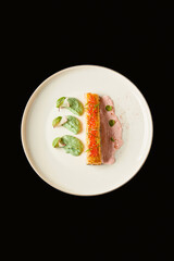 Colorful dish served on a white plate showcasing artful presentation of various textures and flavors from an upscale restaurant