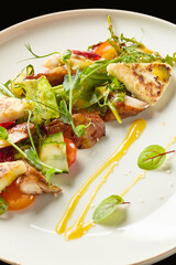Crispy chicken salad with fresh vegetables and vibrant dressing served on a white plate