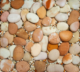 Top view of the nature brown tone stones are arranged and decorated with small pebbles as a background textures