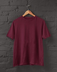 Burgundy T-shirt mockup on hanger placed on a black brick wall for print on demand