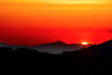 Sunrise over the Greek mountain called Ossa. Like pyramid mountain in Greece. Beautiful orange colours. Copy space. Mountains silhouette. Kissavos mount.