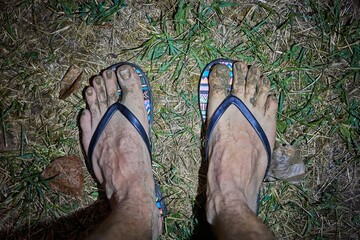 Dirty male feet in slipper with mud