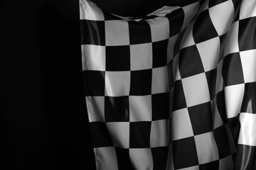 One racing checkered flag on black background, space for text