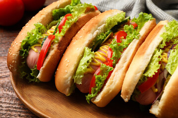 Tasty hot dogs with vegetables on wooden table, closeup
