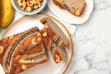 Cut banana bread with nuts on white marble table, flat lay. Space for text