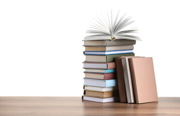 Stack of old books on wooden table against white background