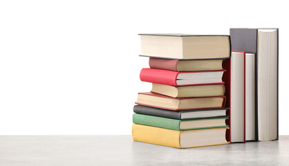 Old books on light grey table against white background