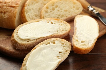 Pieces of bread with butter on wooden table, closeup