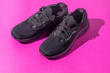 Sneakers sport athletics wear. Pink black color background. New modern shoes