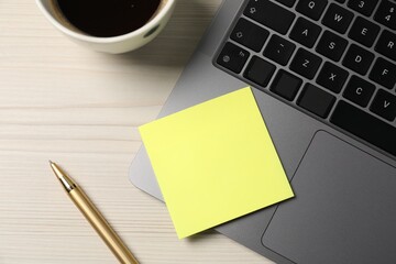 Sticky note, pen, coffee and laptop on wooden table, flat lay