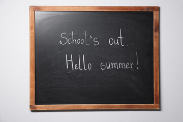 Phrases School's Out and Hello Summer with exclamation mark on blackboard