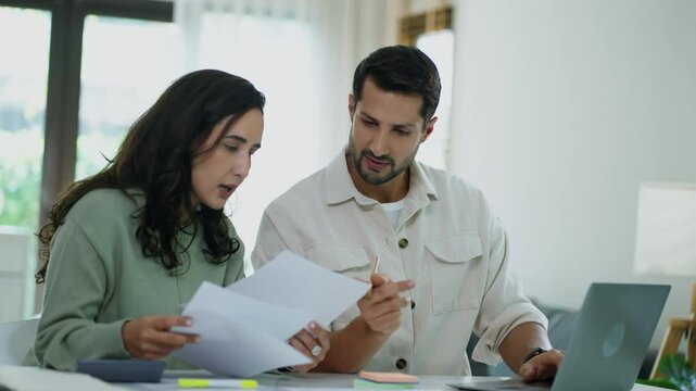 Feeling concerned, the pair discusses budgeting, insurance, and loan terms, supporting each other through financial hardship indoors.

