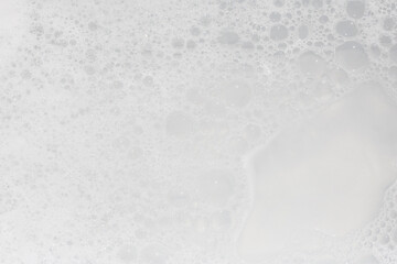 Bubbles cover a smooth surface in a bright environment during a cleaning session