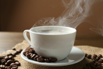 Aromatic coffee in cup and beans on table, closeup
