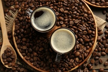 Aromatic coffee in cups and beans on table, flat lay