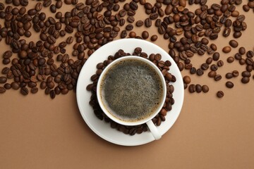 Aromatic coffee in cup and beans on beige background, flat lay