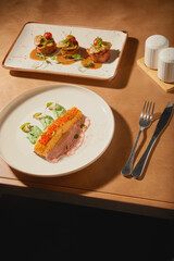 Delightful culinary presentation featuring layered dessert and savory dish on a wooden table