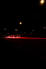 Lights of cars at night. Street line lights. Night highway city. Long exposure photograph night road. Colored bands of red light trails on the road. Background wallpaper defocused blurred photo