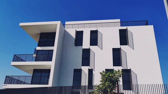 Full View White Color Building With Black Windows And Blue Sky Background. Highrise Tower or Sky Scraper, Building Outdoor Exterior View With Balcony And Terrace PentHouse Apartment G+8 Floor Building