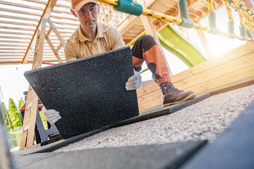 Worker Laying Down Rubber Tiles in a Playground Renovation Project During a Sunny Afternoon in a Suburban Area