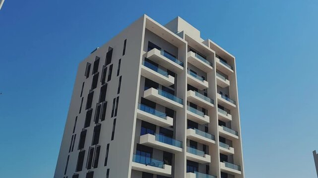 Full View White Color Building With Black Windows And Blue Sky Background. Highrise Tower or Sky Scraper, Building Outdoor Exterior View With Balcony And Terrace PentHouse Apartment G+8 Floor Building