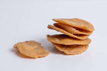 Stack og mathri, or Mathi an Indian a flaky biscuit savoury snack made with all-purpose flour, wheat  flour on white backgropund. Top view.