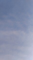 soft blue sky with light clouds, subtle cloud pattern in morning sky, peaceful blue sky with hazy texture