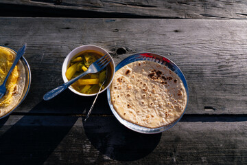 Nepali Trekking Breakfast in the HImalayas Chapati Roti, Black Tea, Potato Curry on a Wooden Table