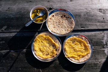 Nepali Trekking Breakfast in the HImalayas Chapati Roti, Black Tea, Potato Curry on a Wooden Table