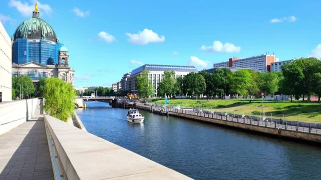 Video of a boat gliding along the Spree River on a beautiful spring morning in Berlin, with the majestic Berliner Dom standing gracefully in the background.